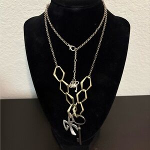 Fossil gold and silver tone key and bow pendant necklace. Preowned.